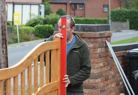 An trusted aluminium gate installer checking a gate with the spirit level